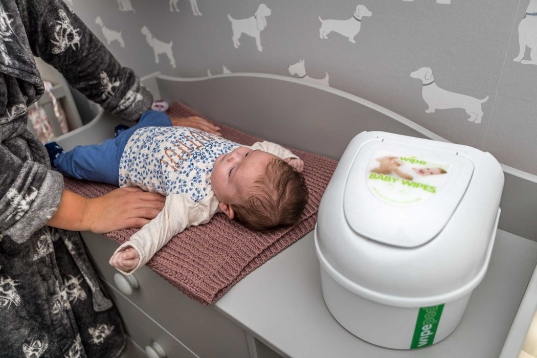 Wipepod® Dispenser next to baby on changing table for easy access to ultra-soft wipes.